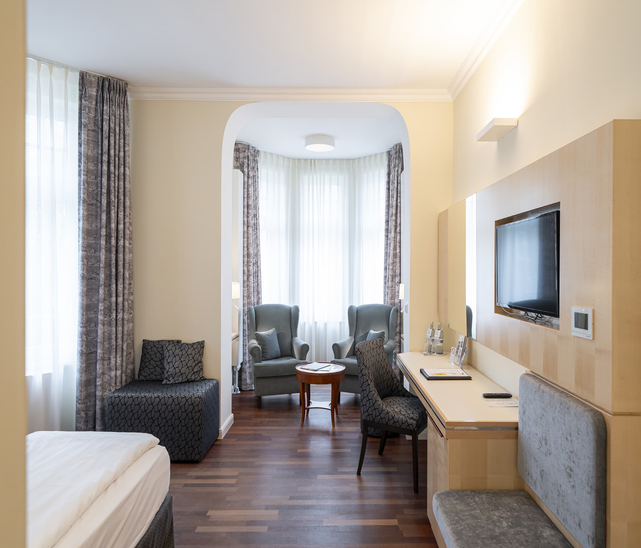 Zimmer mit Erker, Sesseln und Schreibtisch