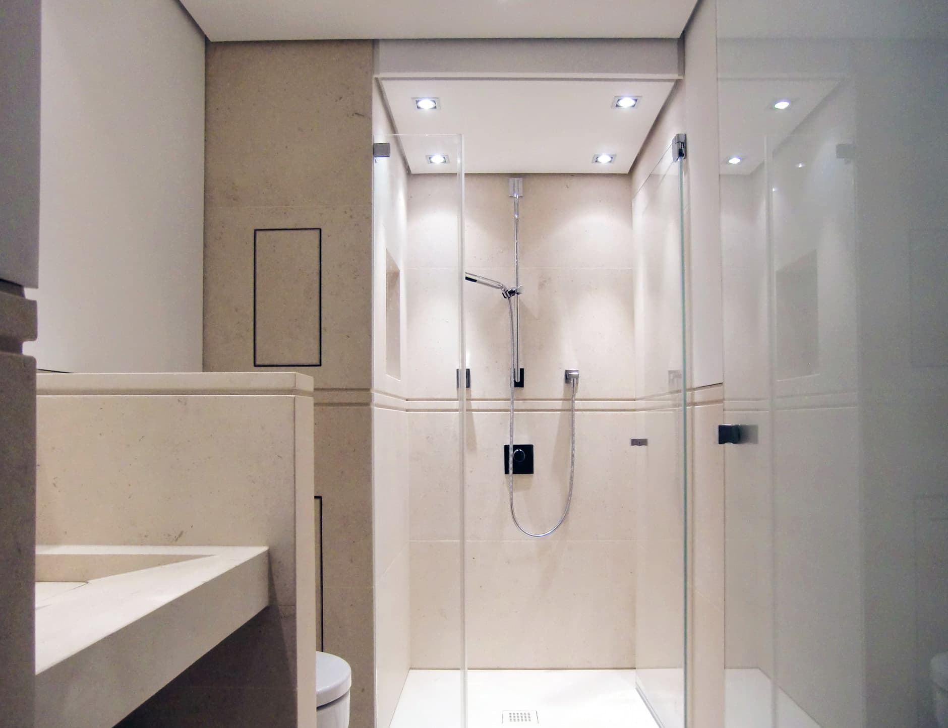 Dusche mit Glaswand und Natursteinverkleidung